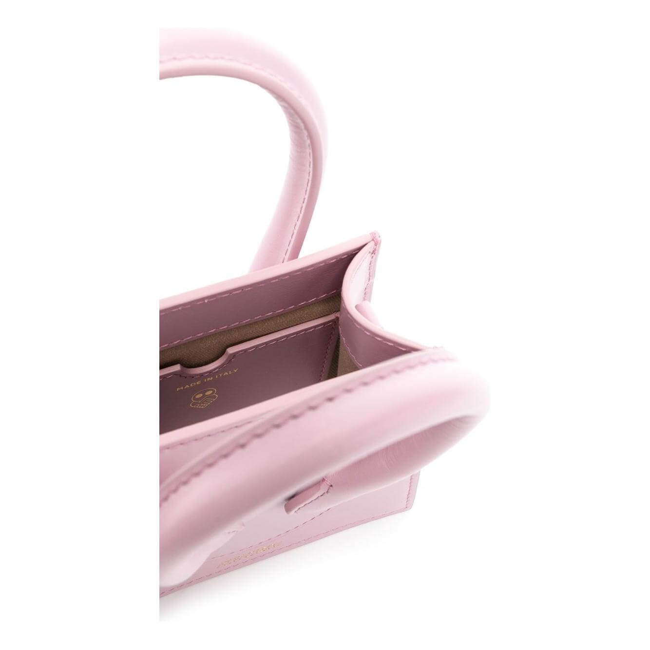 Close-up view of a light pink Az Factory x Ester Manas Cake mini tote bag with rolled handles and leather detailing.