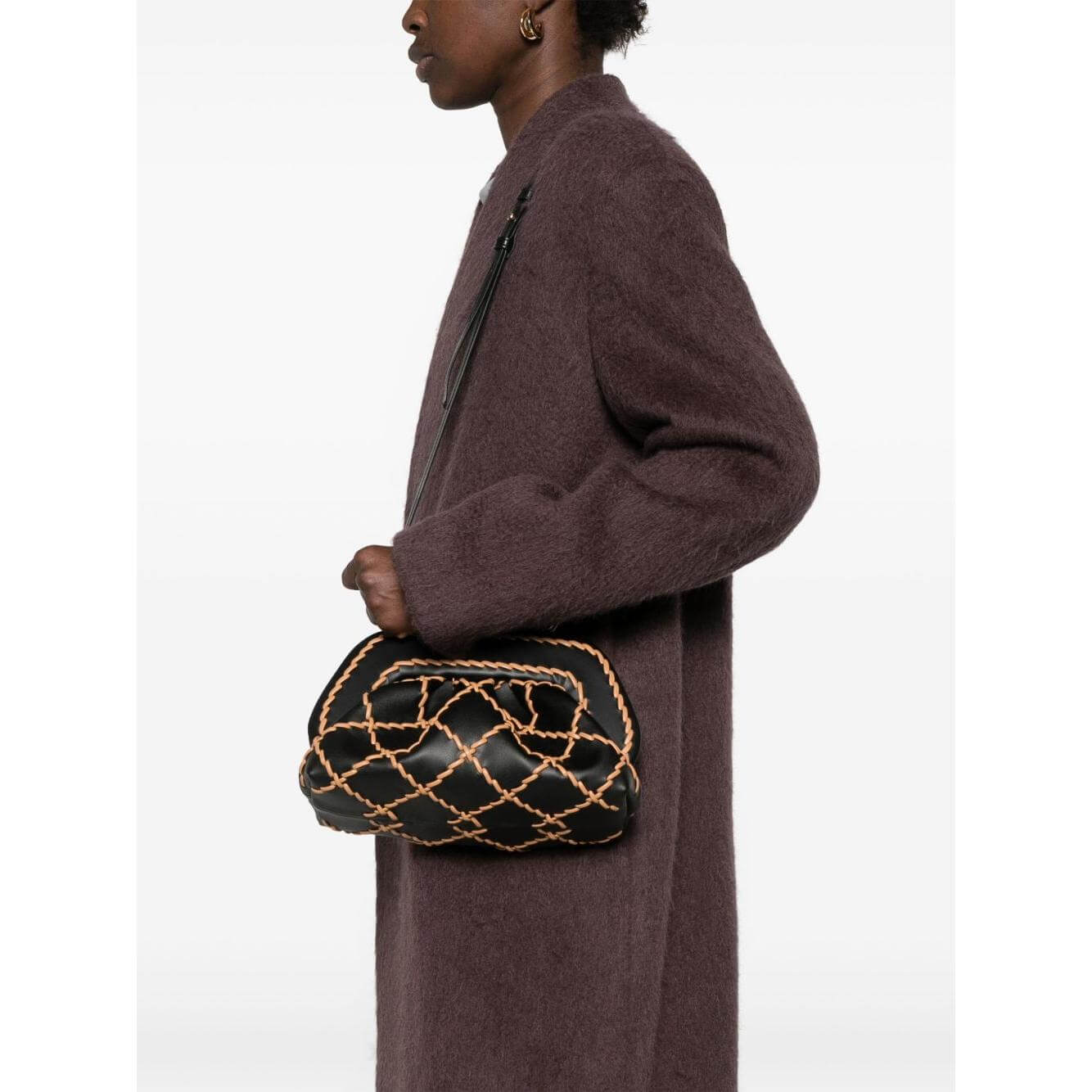 Alt Tag: Person holding Themoire' Tia black bamboo clutch bag with protective dust bag, featuring quilted design and compact size.