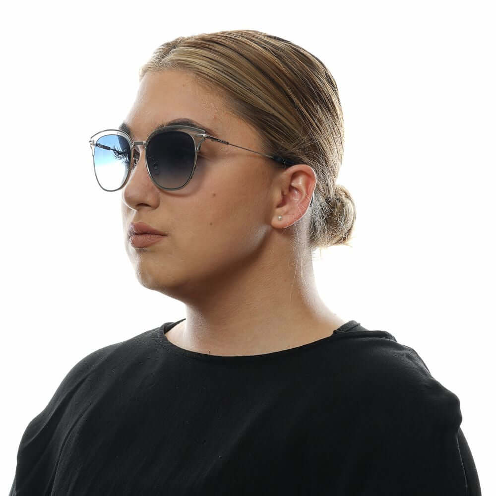 Woman wearing Police multicolor butterfly sunglasses with blue gradient lenses and silver metal frame.