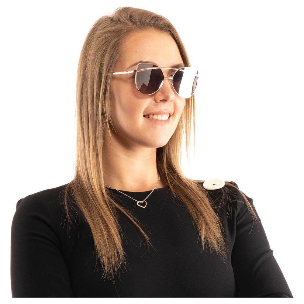 Woman wearing Guess rose gold butterfly sunglasses with mirrored lenses and metal frame.