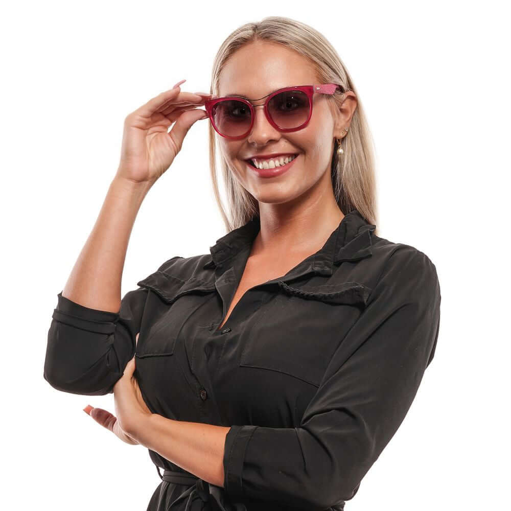 Woman wearing Police Purple Oval Sunglasses, smiling in black outfit