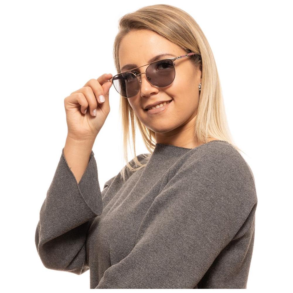 Woman wearing Carolina Herrera silver aviator sunglasses with full-rim style, blue lenses, and spring hinge design.