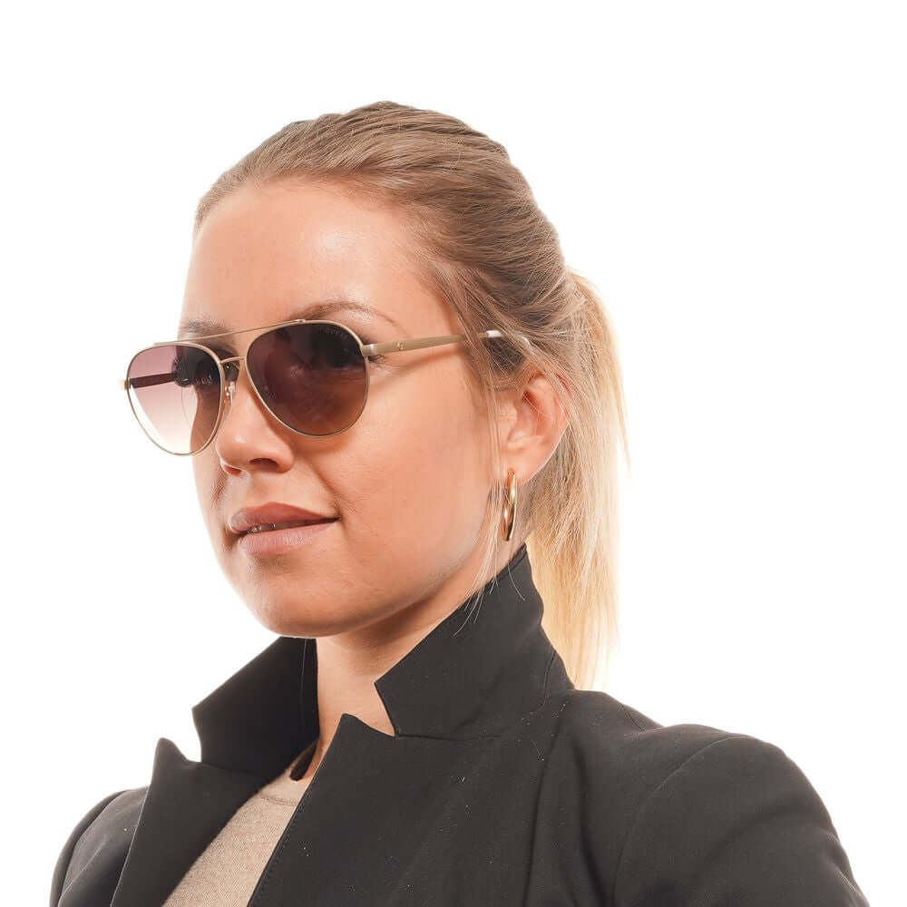 Woman wearing Guess Gold Aviator Sunglasses with brown gradient lenses and full-rim metal frame