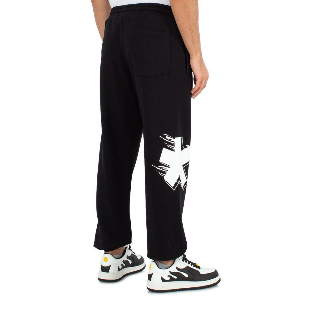 Comme Des Fuckdown black cotton men's sweatpants with striking back logo print, worn by model, highlighting bold streetwear style.