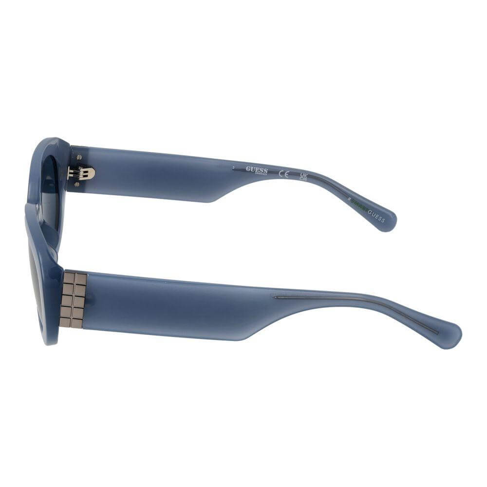 Guess blue women’s sunglasses with full-rim oval plastic frame, side view showing temples and hinges, offering 100% UVA & UVB protection.