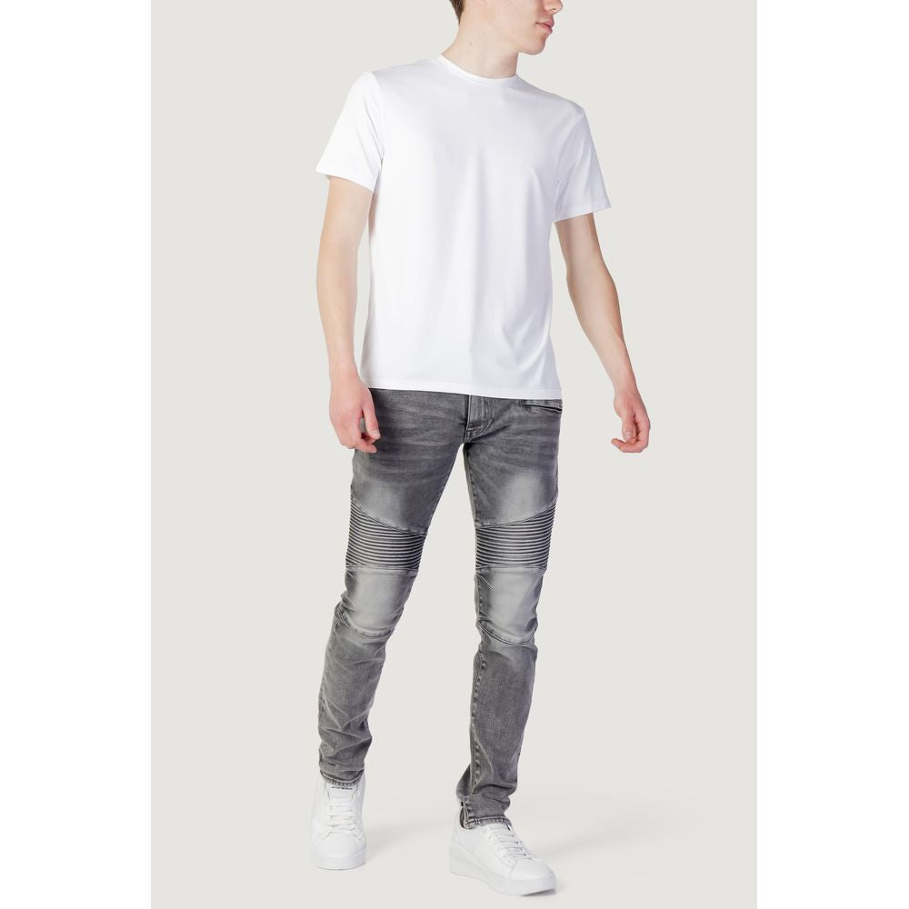 Men's spring/summer collection white polyester T-shirt, made with 99% polyester and 1% elastane, paired with grey jeans and white sneakers.