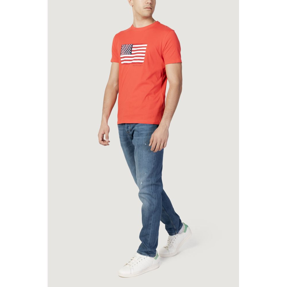 Man wearing U.S. Polo Assn. red cotton t-shirt with American flag graphic, paired with jeans and white sneakers.