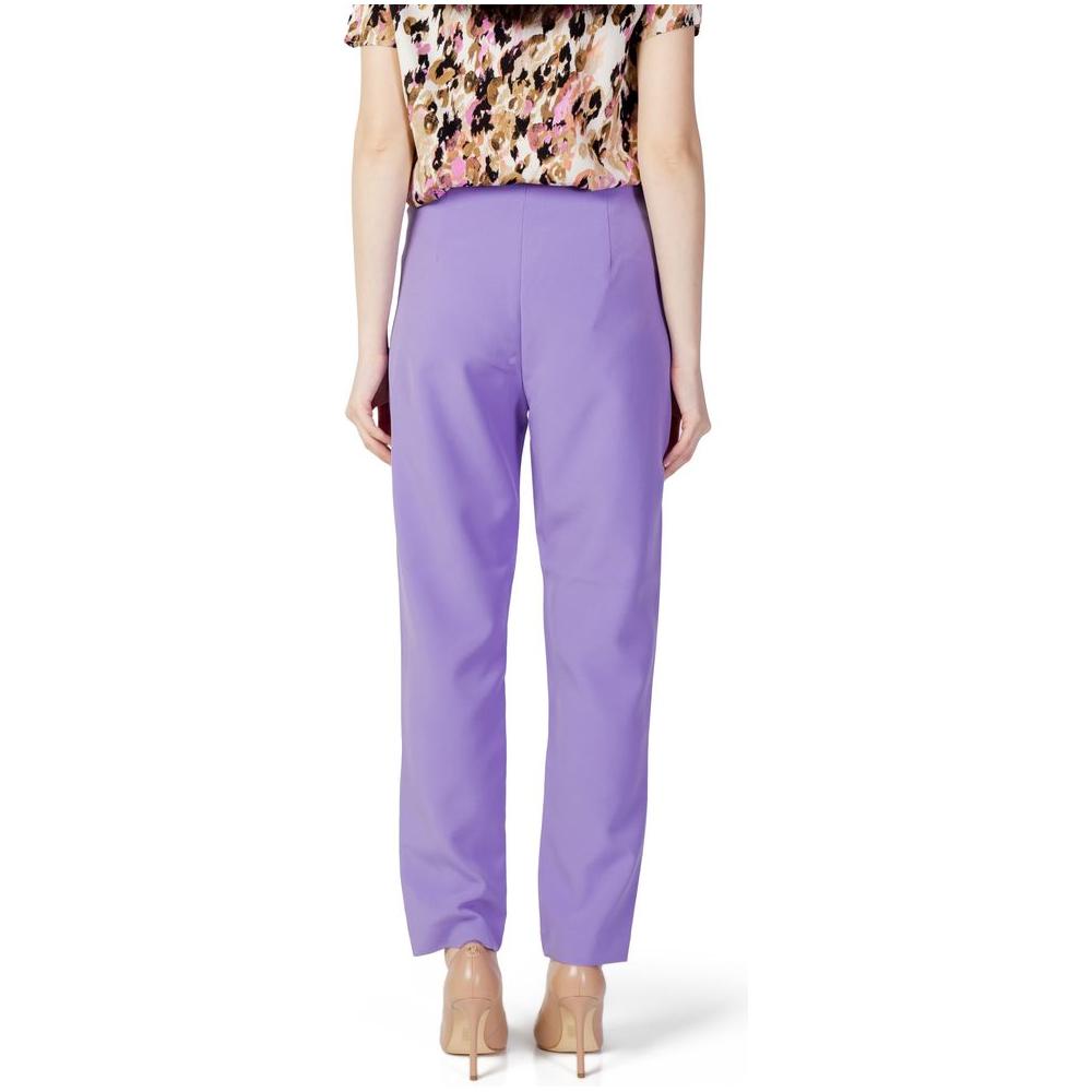 Woman wearing only purple polyester cigarette pants from spring/summer collection, featuring recycled polyester and elastane.