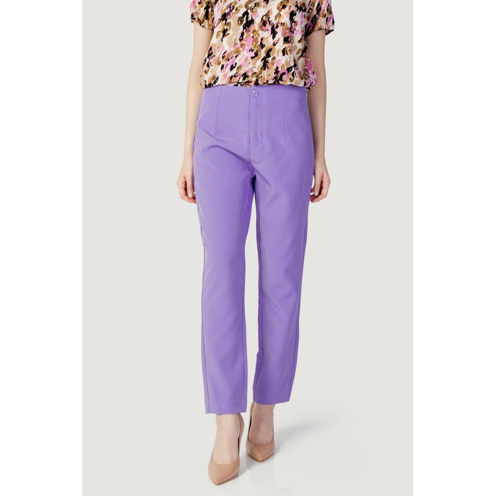 Woman modeling purple polyester cigarette pants, spring/summer collection, includes recycled materials, stylish and eco-friendly fashion.