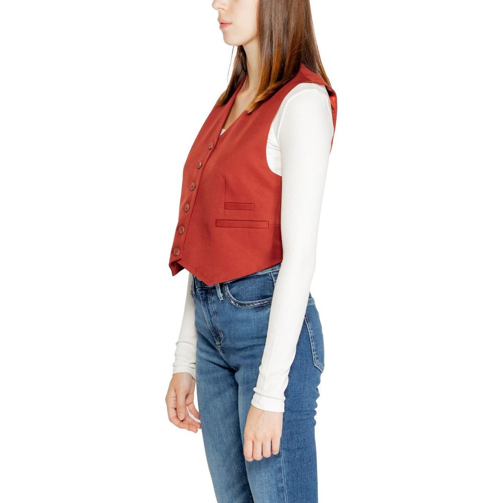 Side view of a woman wearing a red Vero Moda polyester vest from the Fall/Winter collection, styled with a white top and jeans.