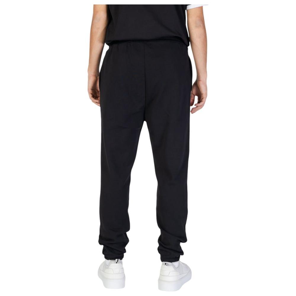 Rear view of model wearing Underclub Fall/Winter black cotton jeans, showcasing straight fit and 100% cotton composition.