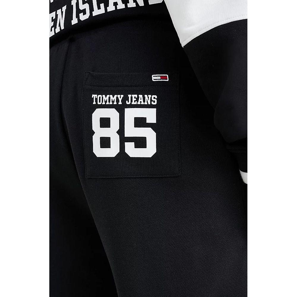 Close-up of black Tommy Hilfiger jeans with 'Tommy Jeans 85' logo on pocket, part of men's spring/summer cotton collection.