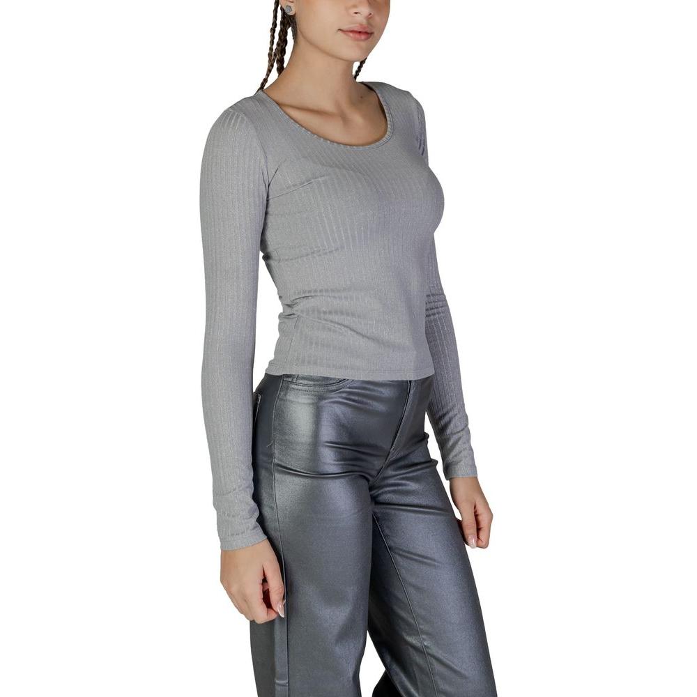 Woman wearing Vero Moda silver long-sleeved recycled polyester top with viscose, metallic fibers, and elastane blend.