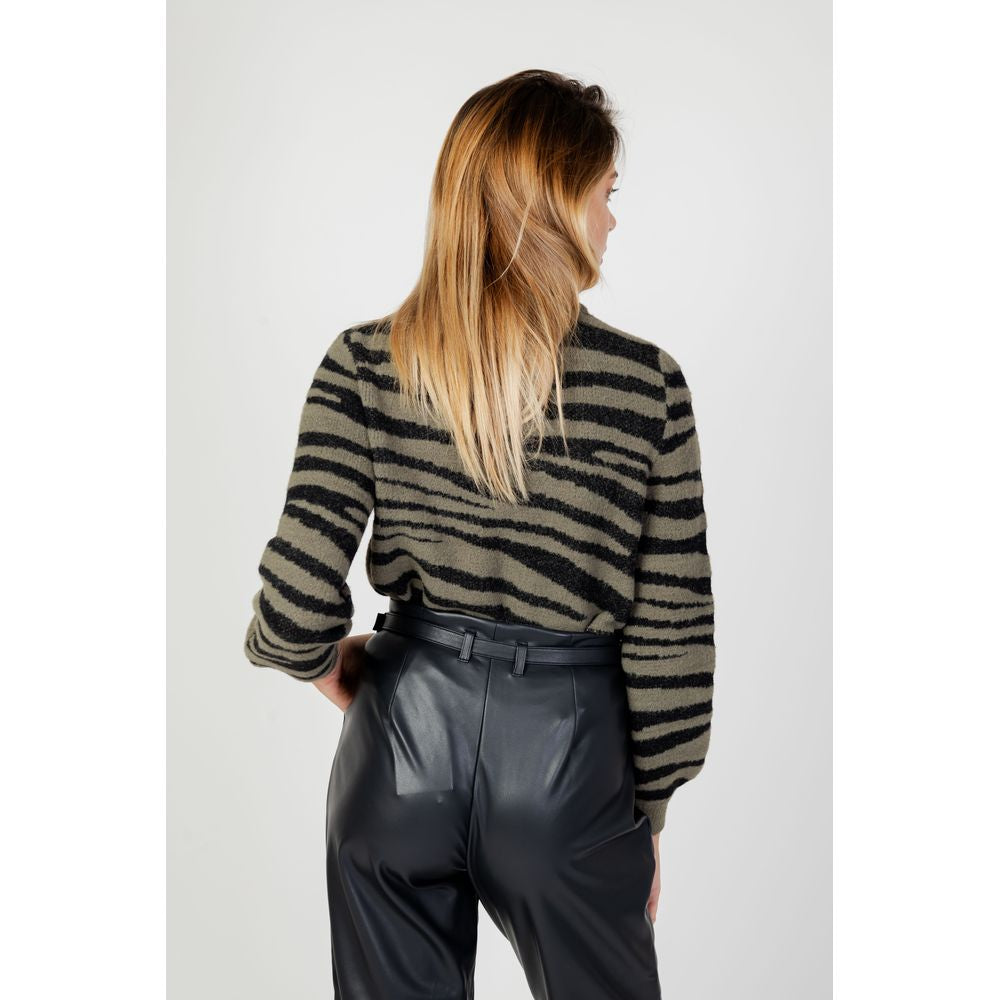 Back view of woman wearing Jacqueline De Yong green nylon zebra-striped sweater, paired with black leather pants for fall/winter fashion.