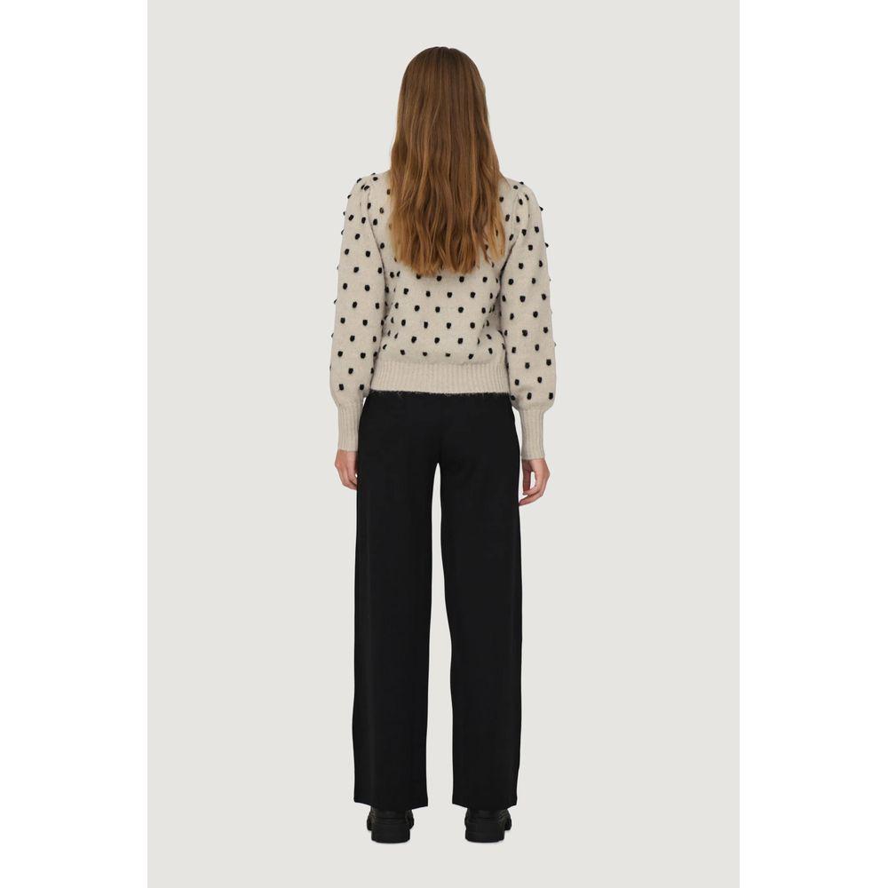 Rear view of woman wearing Jacqueline De Yong beige polka dot sweater, part of autumn-winter collection, made of 100% polyester.