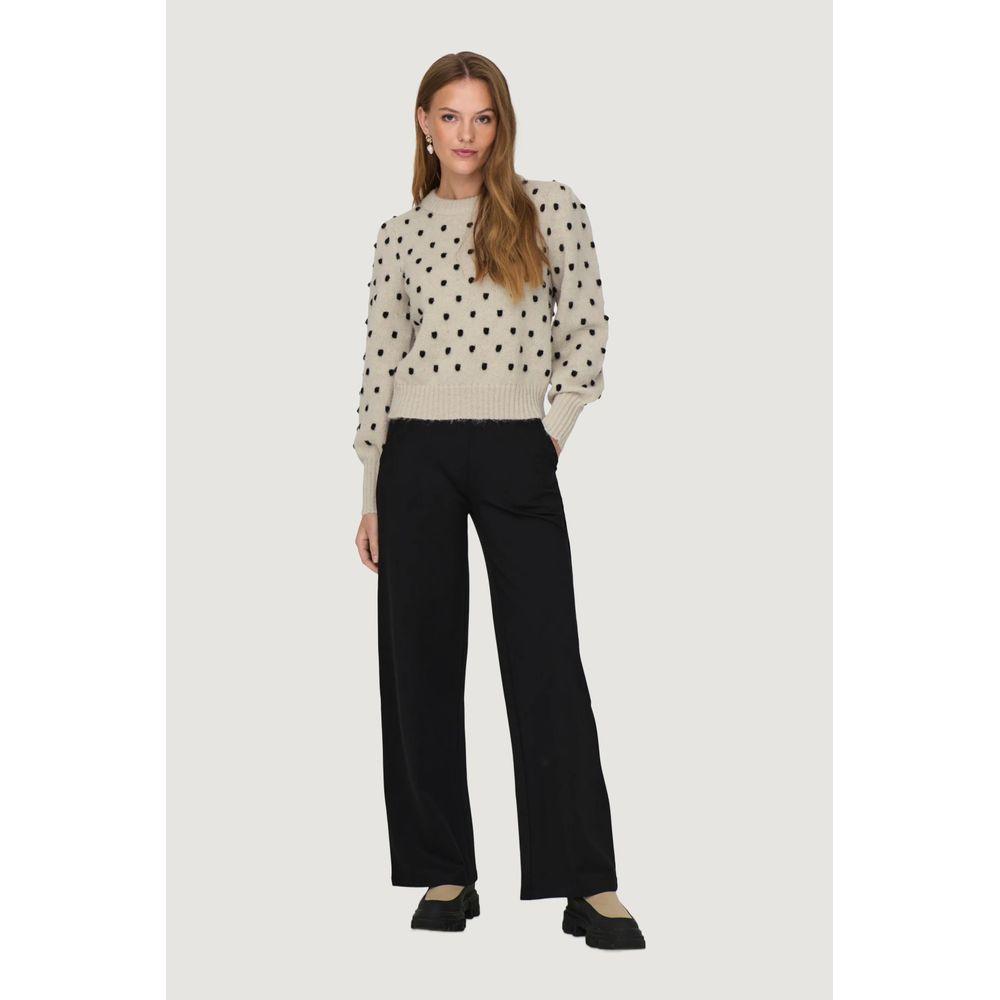 Woman wearing Jacqueline De Yong beige polyester sweater, autumn/winter collection, with black pants. Trendy women's fashion.