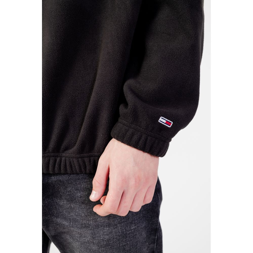 Tommy Hilfiger men's black recycled polyester sweater, close-up of sleeve with logo, Fall/Winter collection.