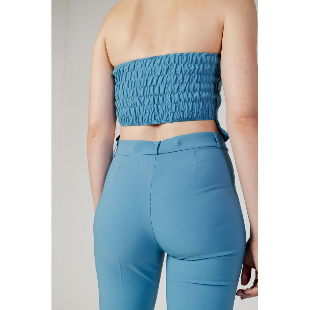 Back view of woman wearing turquoise Rinascimento women's top and pants, autumn/winter collection, polyester elastane blend.