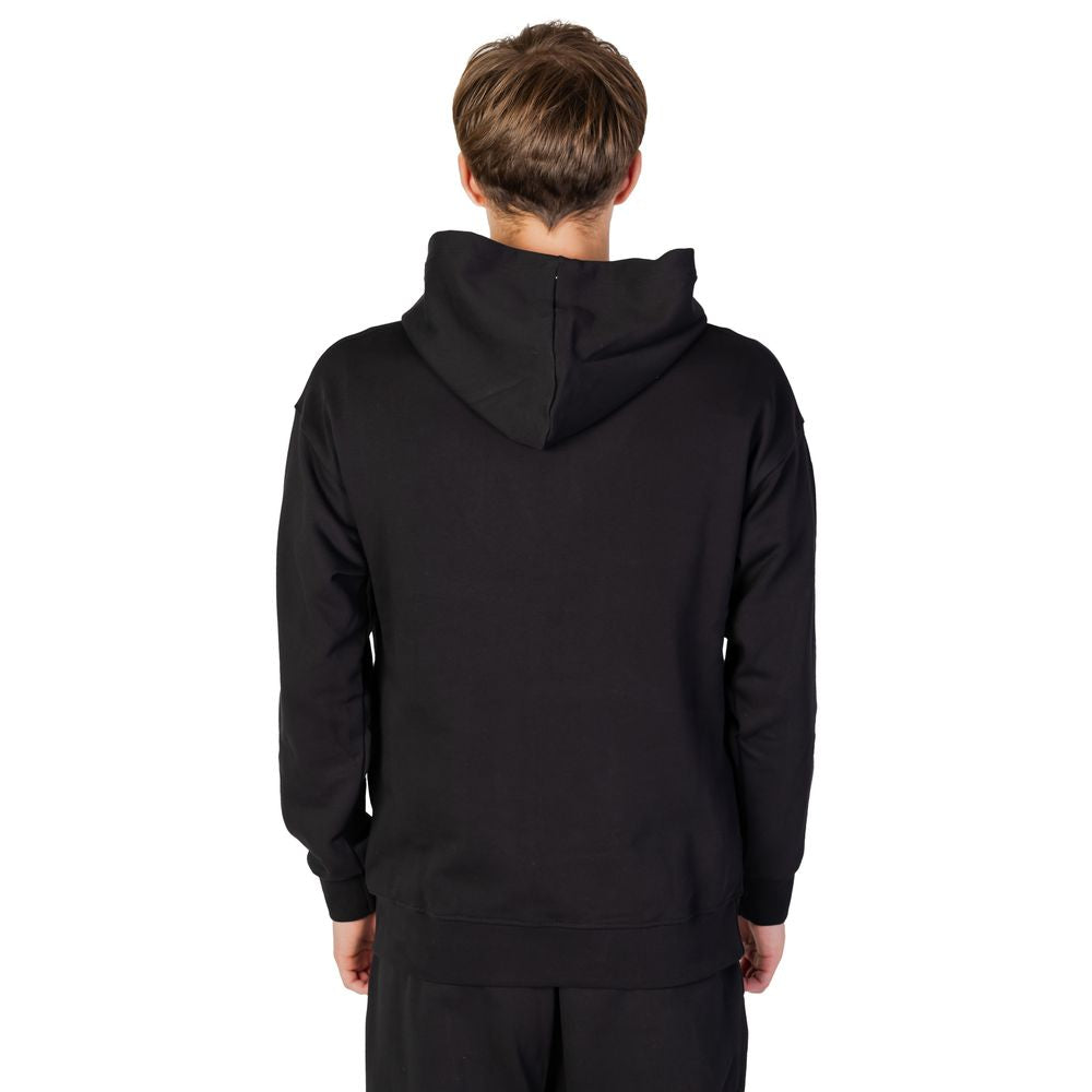 Back view of a man wearing a black cotton hooded sweater from Underclub's autumn/winter collection.