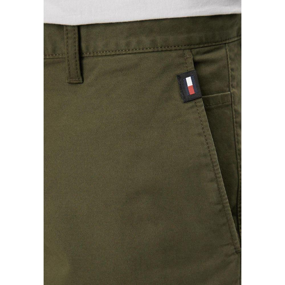 Close-up of green Tommy Hilfiger men's Bermuda shorts made from organic cotton with logo detail, perfect for spring/summer collection.