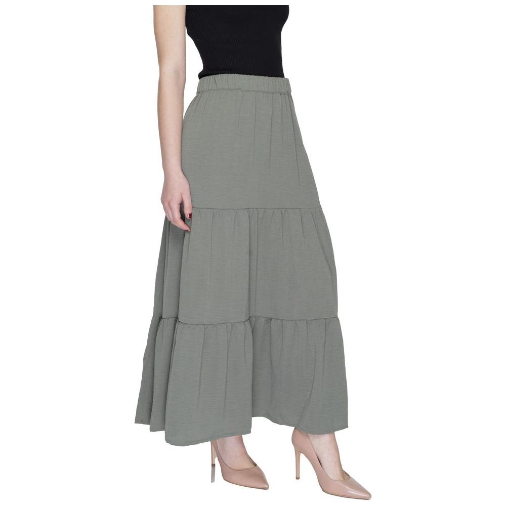 Woman wearing Jacqueline De Yong green polyester long skirt, perfect for spring and summer fashion, showcasing trendy style and comfort.