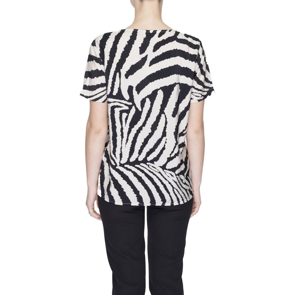 Back view of a woman wearing a zebra print short-sleeve top, paired with black pants, showcasing a casual outfit style.