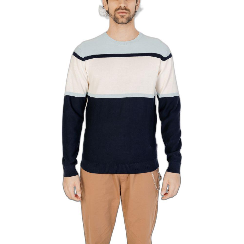 Man wearing a blue and cream color-block sweatshirt with tan pants, front view on a white background.