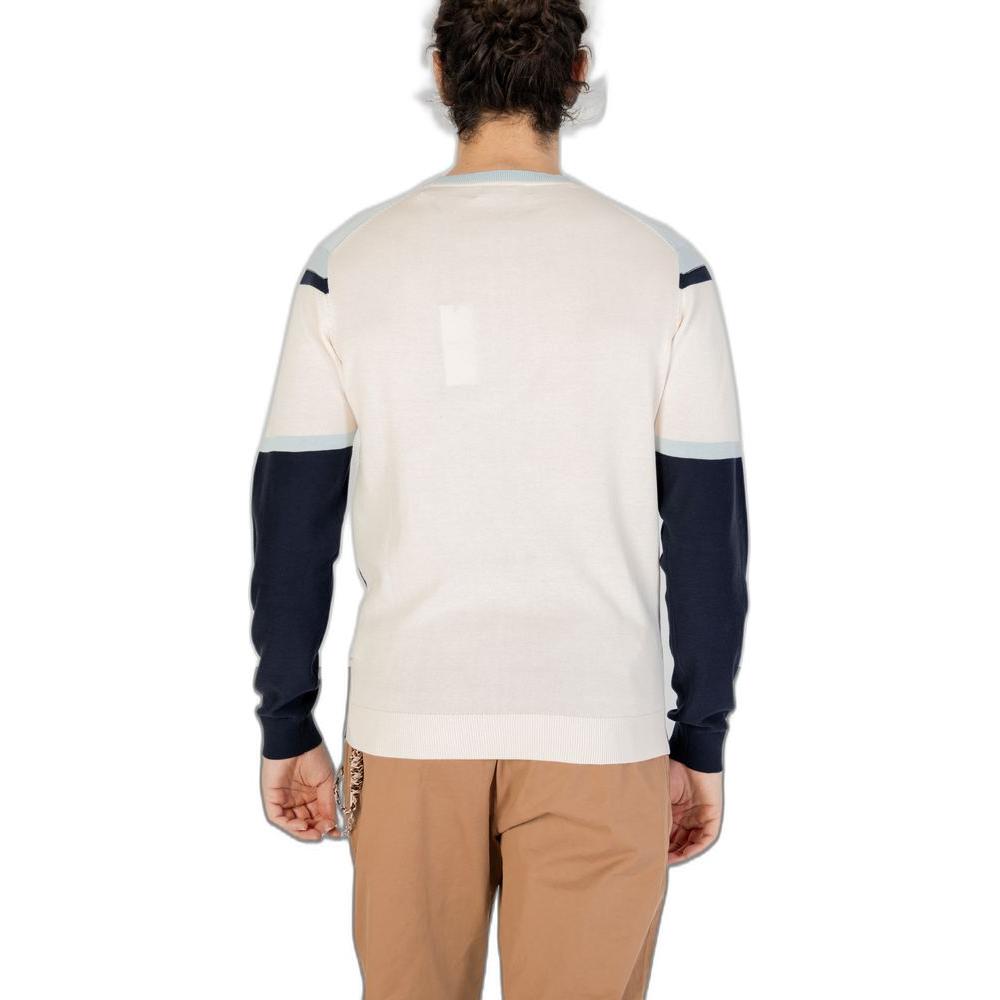 Back view of a man wearing a stylish long-sleeve sweater with contrast sleeves, paired with brown pants, isolated on a white background.