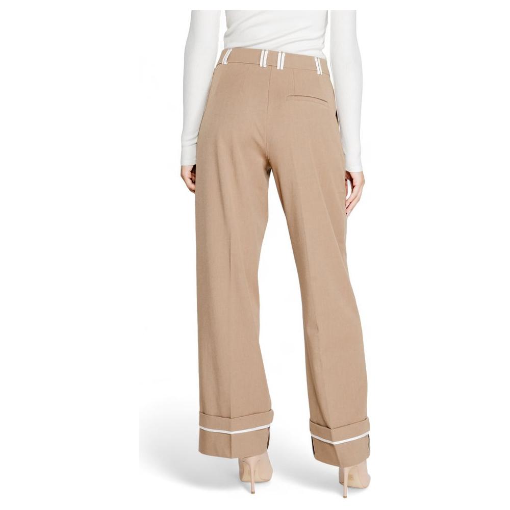 Back view of women's fall/winter brown recycled polyester pants with white stripe detailing, showcasing sustainable fashion.