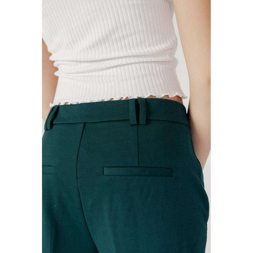 Model wearing Only Green women's cigarette pants, polyester and elastene blend, part of fall/winter collection.
