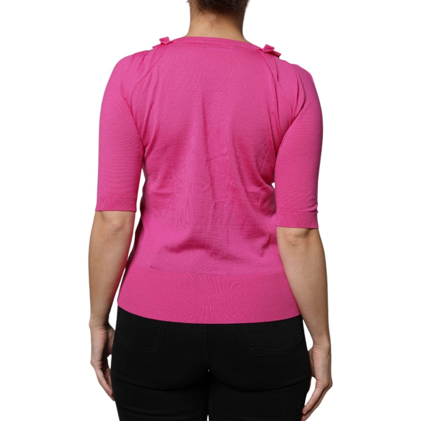 Back view of model wearing Dolce & Gabbana pink wool button-down cardigan sweater, short sleeves, elegant design, high craftsmanship.