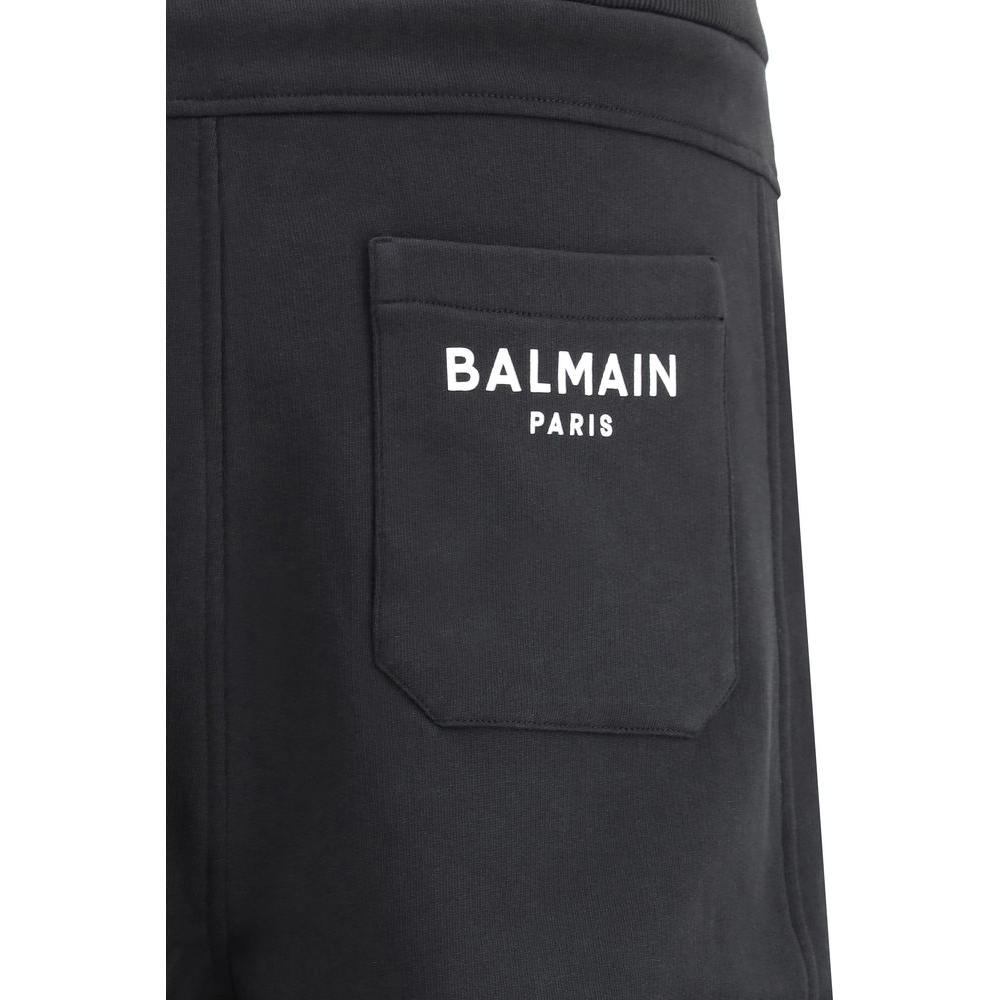 Close-up of black Balmain sweatpants with branded back pocket and elastic waistband, showcasing luxury jogger style and monochrome design.