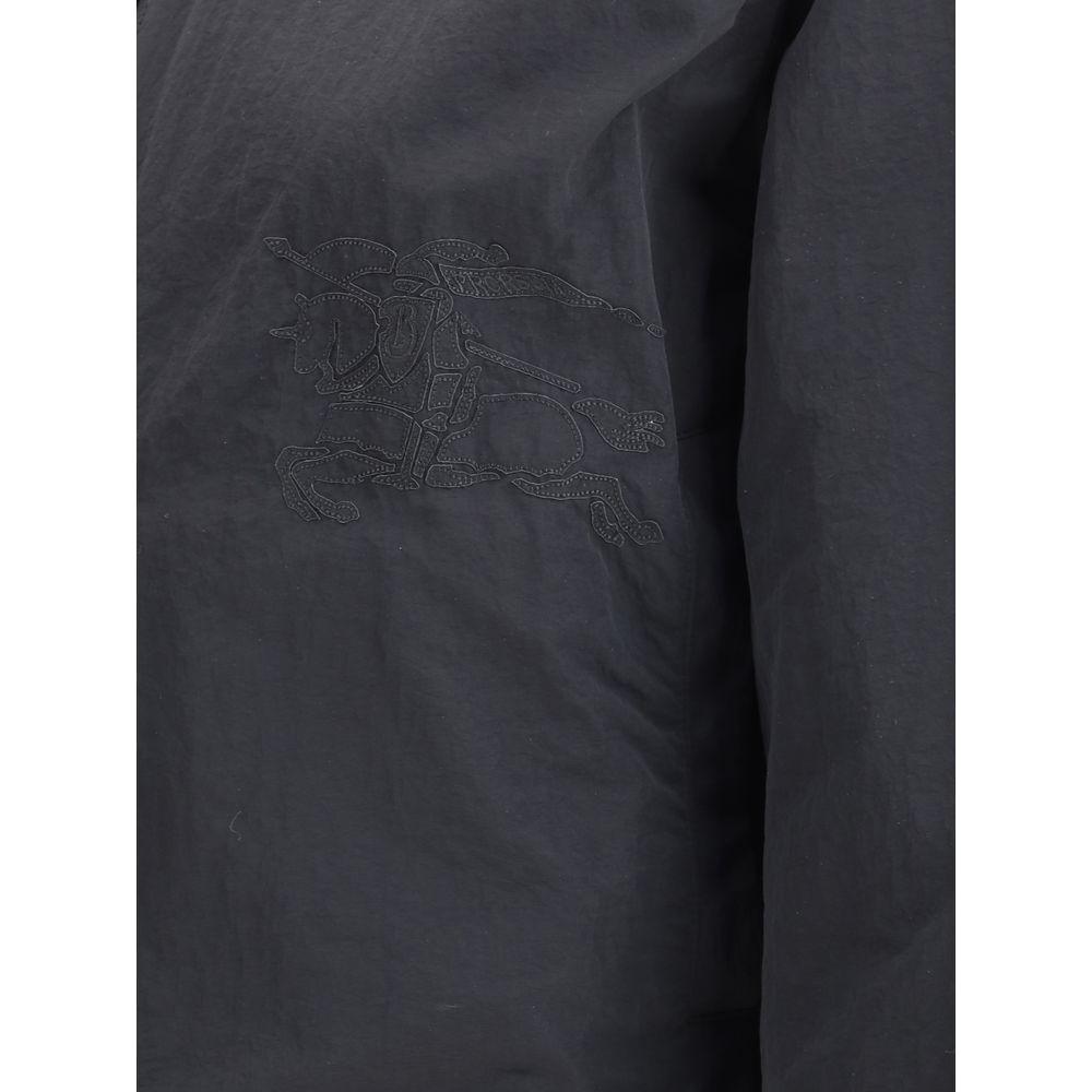 Close-up of Burberry reversible jacket showing stitched logo on dark fabric.