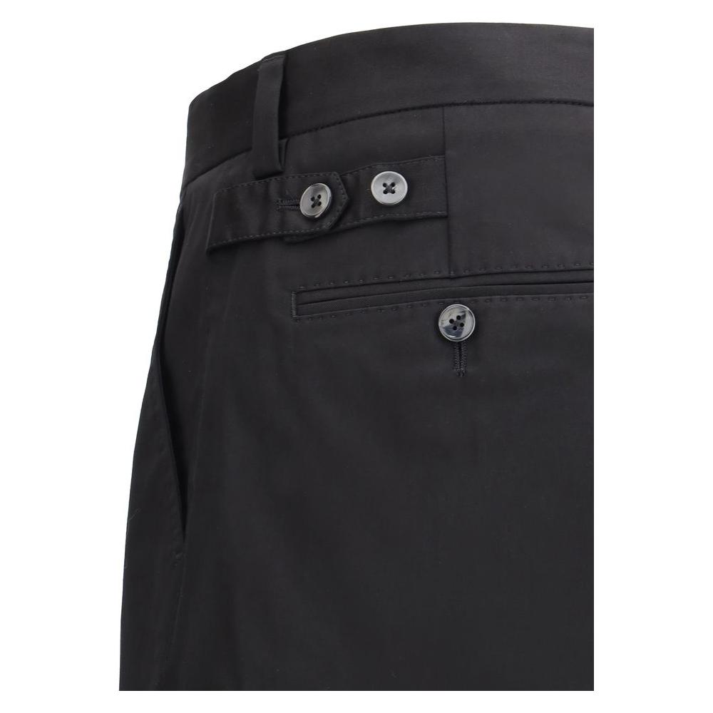 Close-up of Dolce & Gabbana cotton pants showing back welt pockets, button details, and waistband loops, mid-rise design.