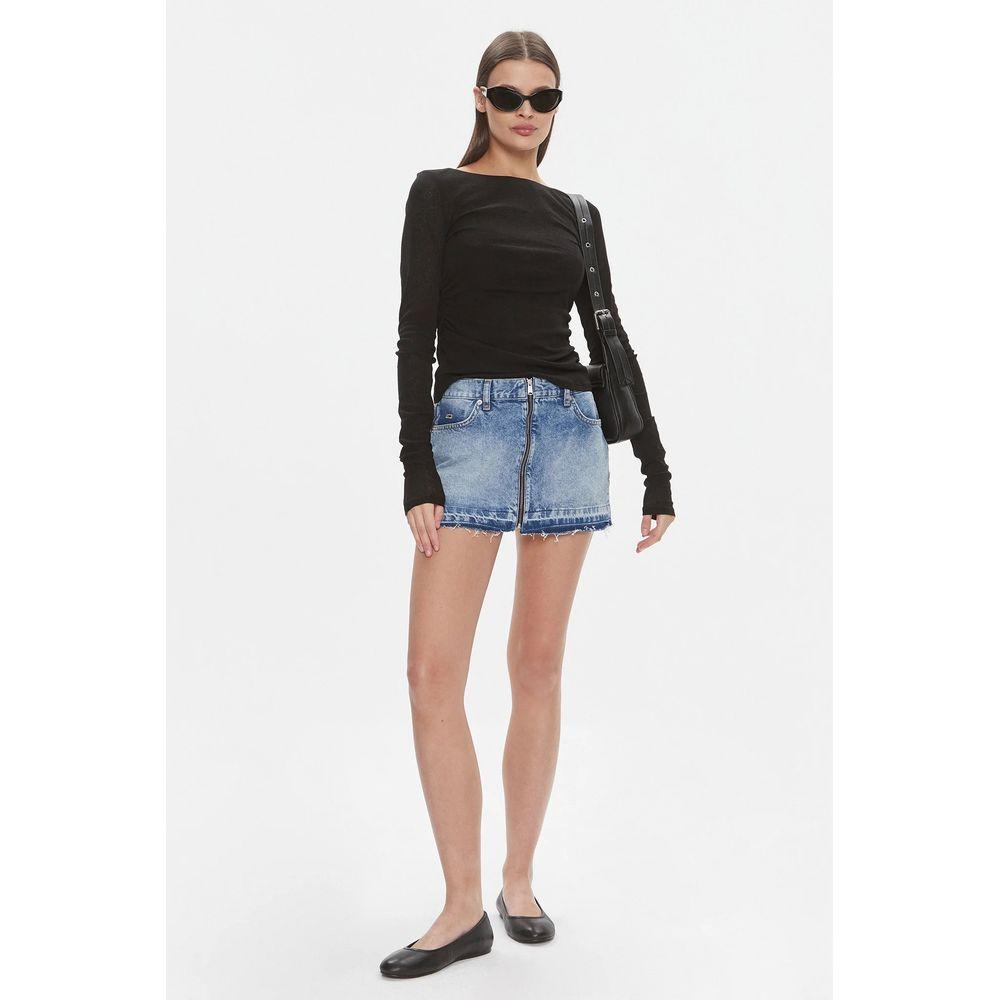 Woman wearing a Tommy Hilfiger blue recycled cotton mini skirt from the Spring/Summer collection, paired with a black top and sunglasses.