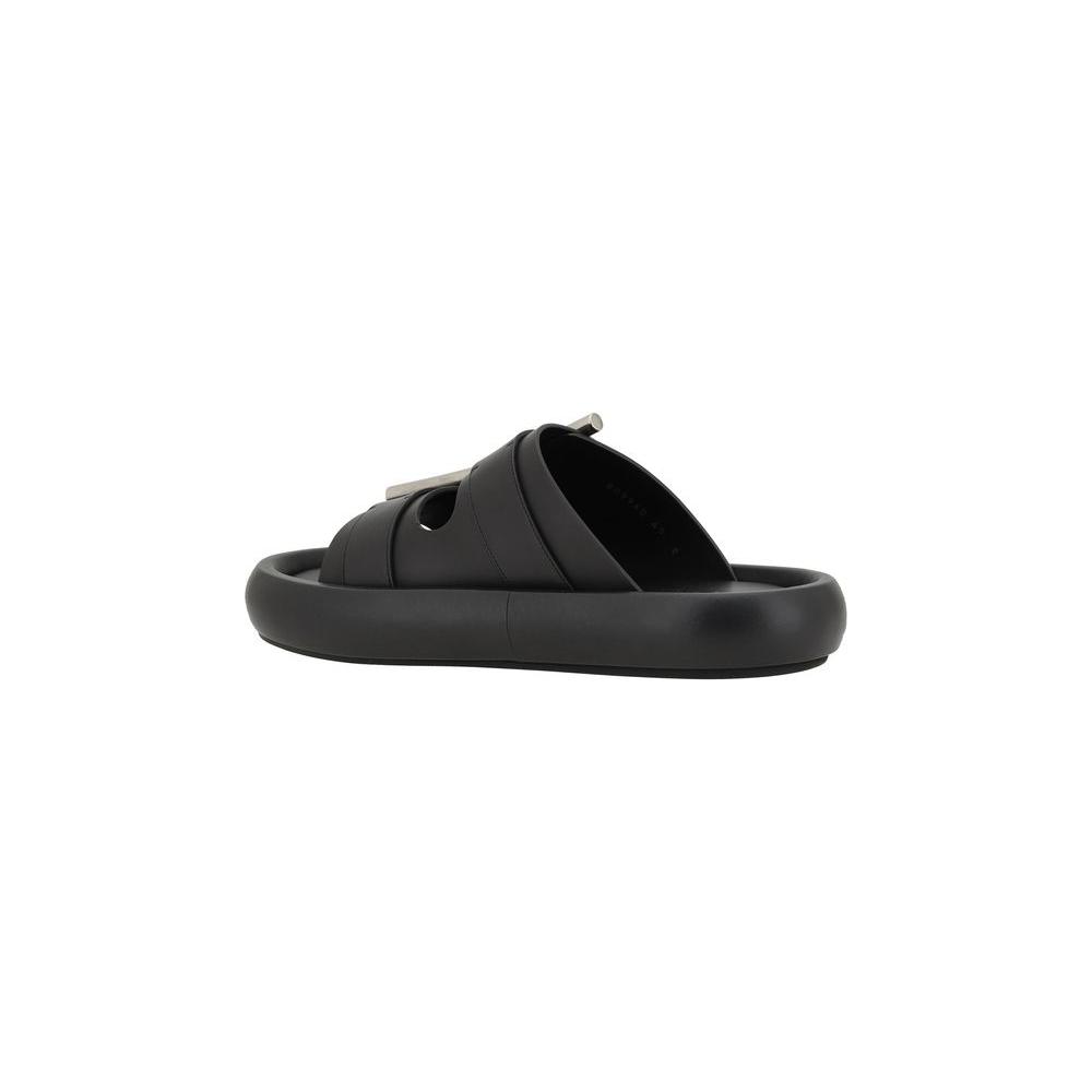 Alexander McQueen leather sandals with metal buckles, bold design, and logo-embossed sole, showcasing modern style and sophistication.