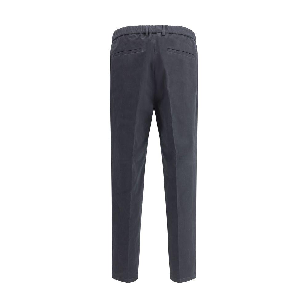 Back view of Jil Sander cropped pants featuring welt pockets, elasticized waistband, and minimalist design in dark color.