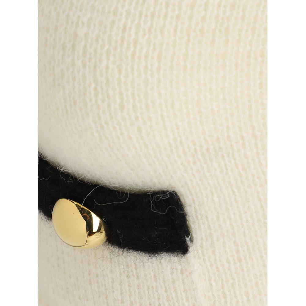 Close-up of Alessandra Rich alpaca wool top showing monochrome pattern and gold-accented welt pocket detail.