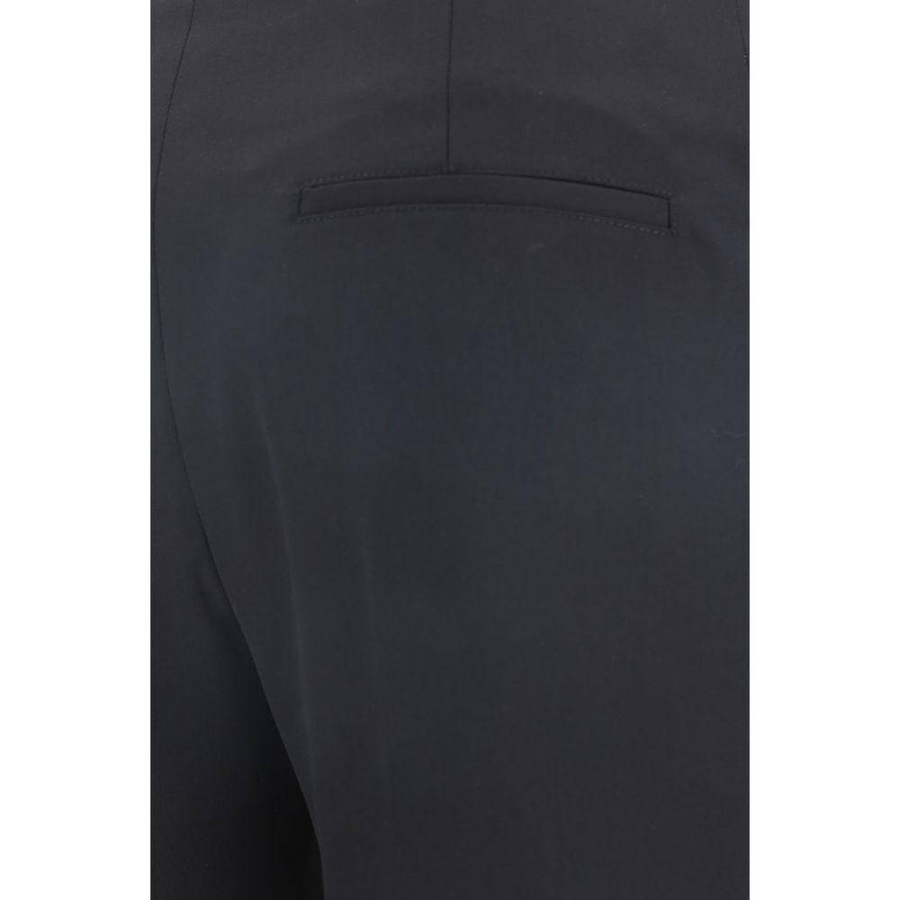 Close-up view of Chloé virgin wool pants featuring back welt pocket, monochrome design, and asymmetrical hems for a stylish look.