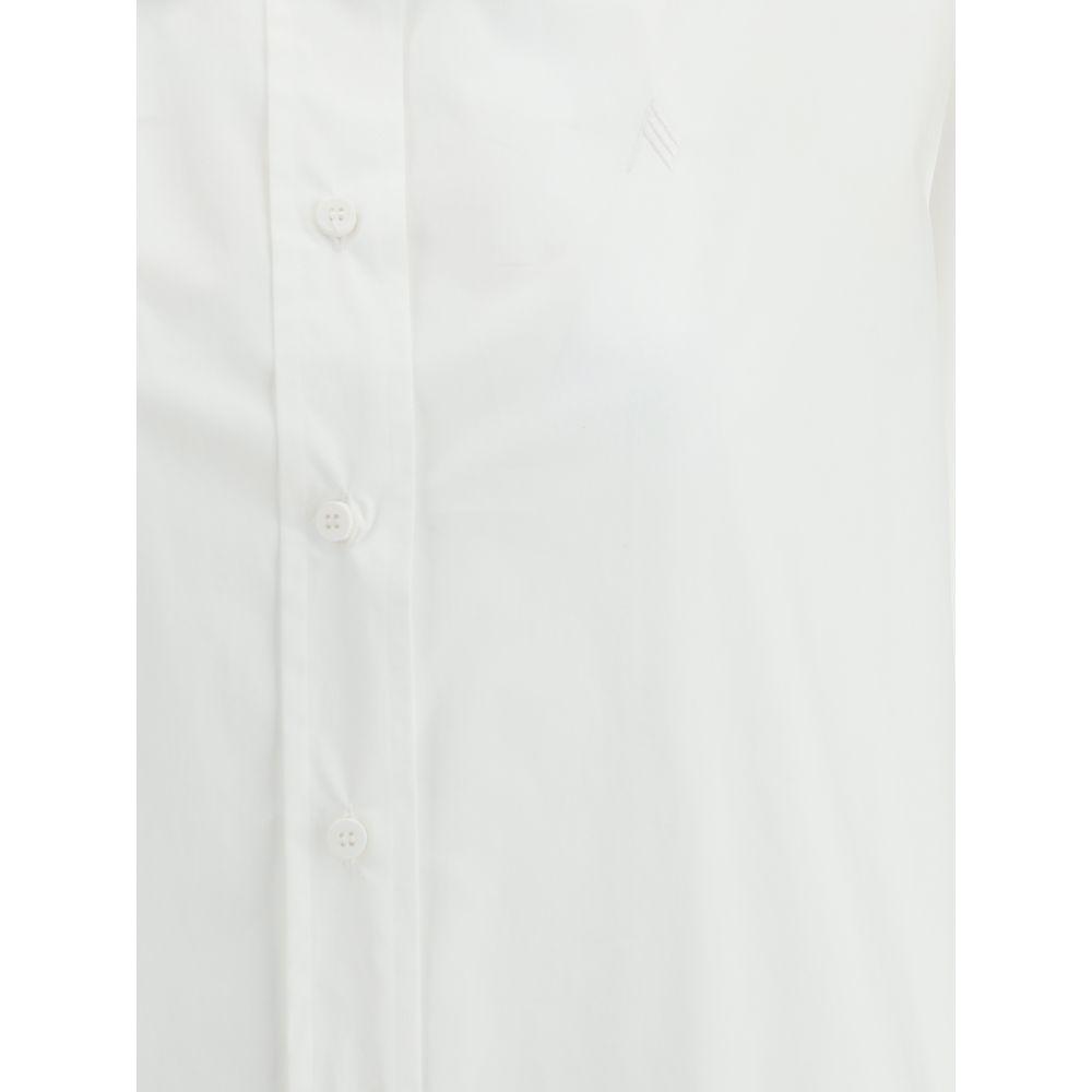 Close-up of The Attico cotton shirt with button closure and embroidered logo, highlighting its oversized design and asymmetrical slit.