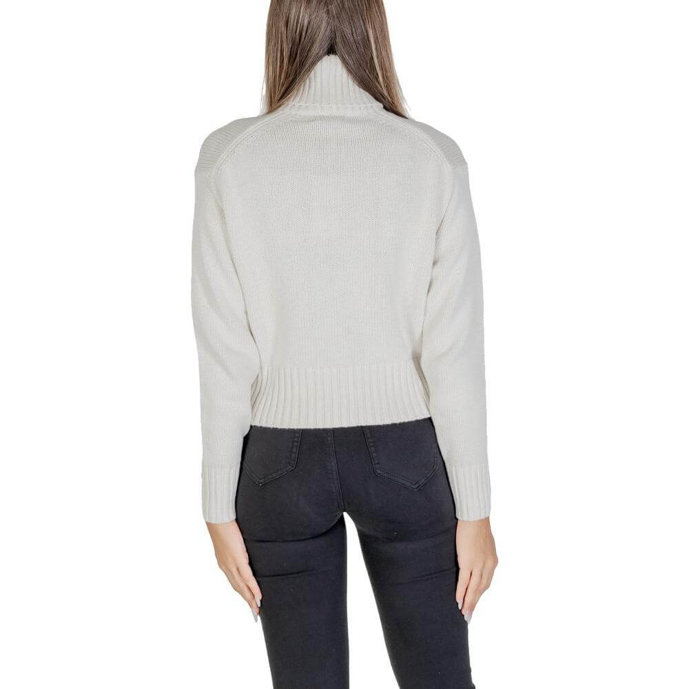 Back view of woman wearing Calvin Klein cream cotton sweater, fall/winter knitwear collection, showcasing ribbed hem and long sleeves.