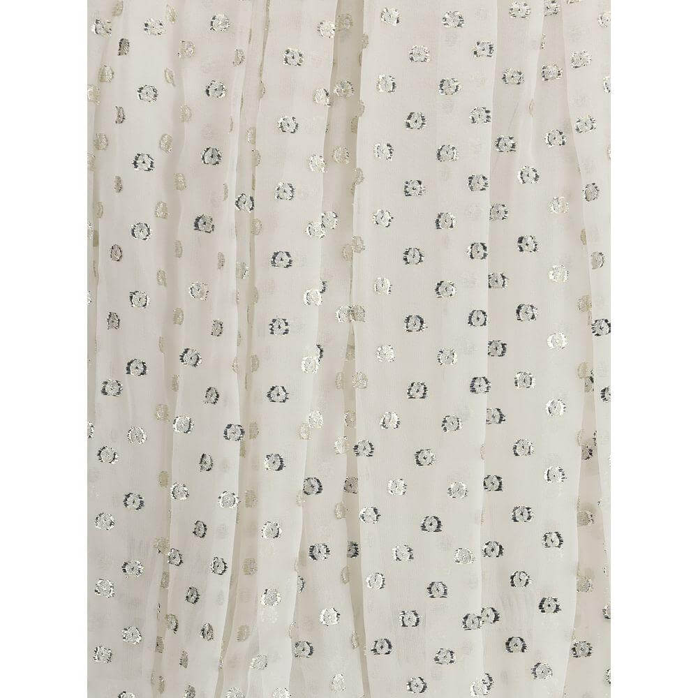 Close-up of shimmering polka dot embroidery on Chloé's off-shoulder shirt, featuring elegant and romantic detailing.