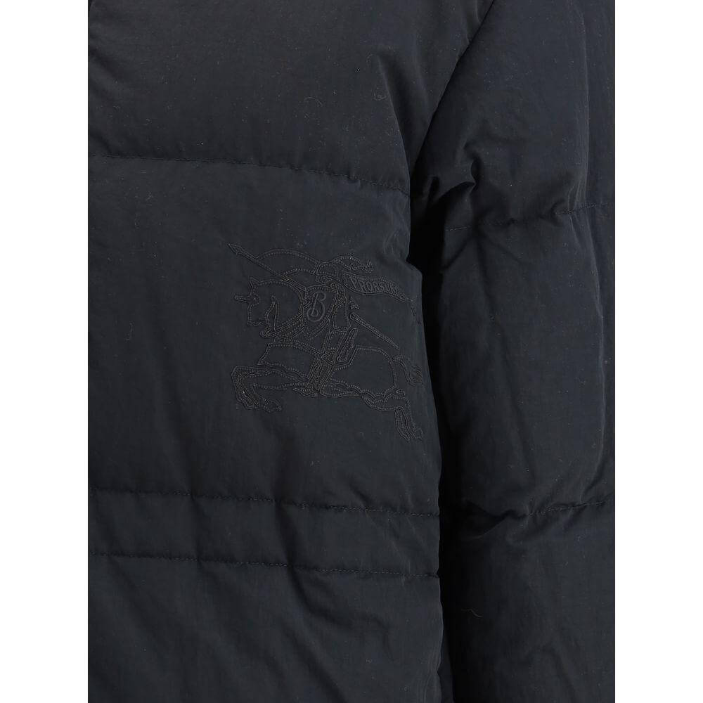 Close-up of Burberry reversible down jacket showing logo embroidery and quilted design in black fabric.