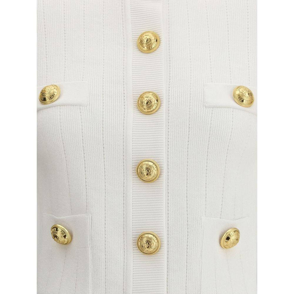 Balmain white cardigan with gold embossed button closure, ribbed crew neck, and buttoned welt pockets, showcasing sleek and sophisticated style.