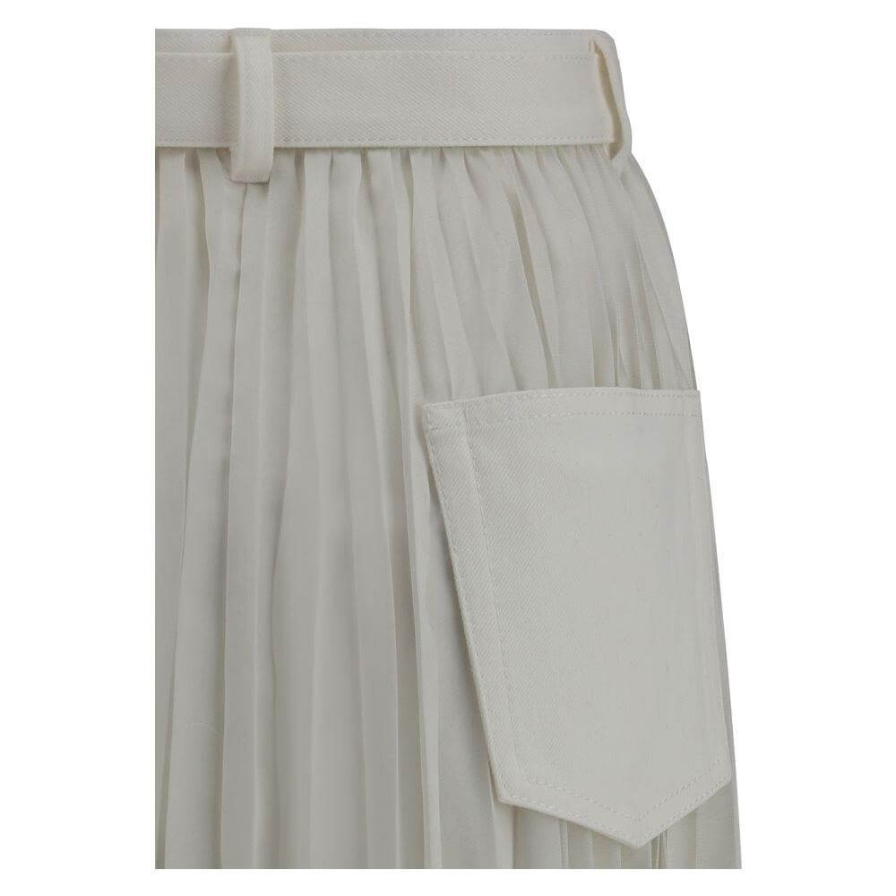 Sacai Denim plissè midi skirt with pleated detail and practical pocket shown in close-up.