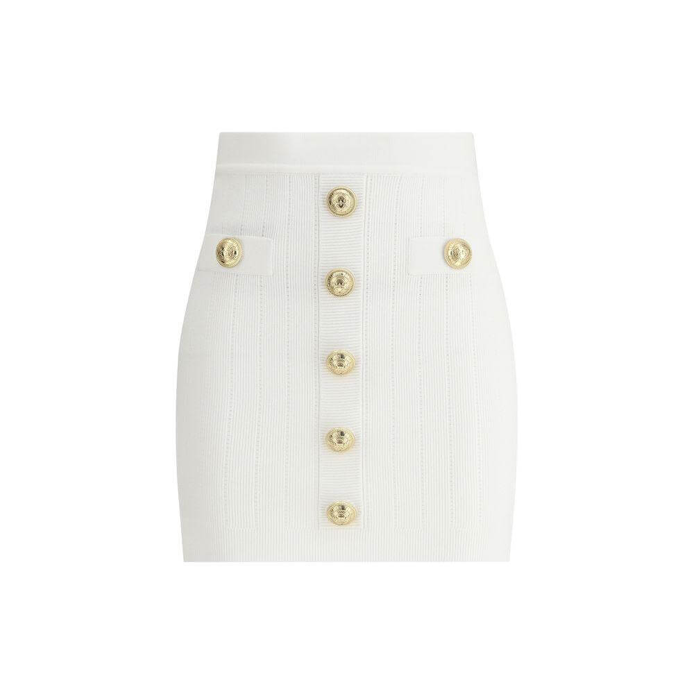 Balmain mini skirt with ribbed design, gold lion's head buttons, faux welt pockets, perforated details, and contrasting zipper closure.