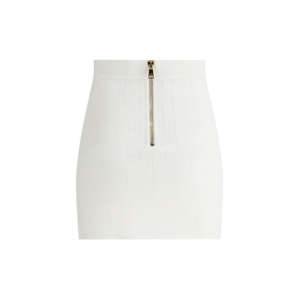 Balmain ribbed mini skirt with perforated details, back zipper, faux pockets, lion’s head button, monochrome pattern, and close fit.