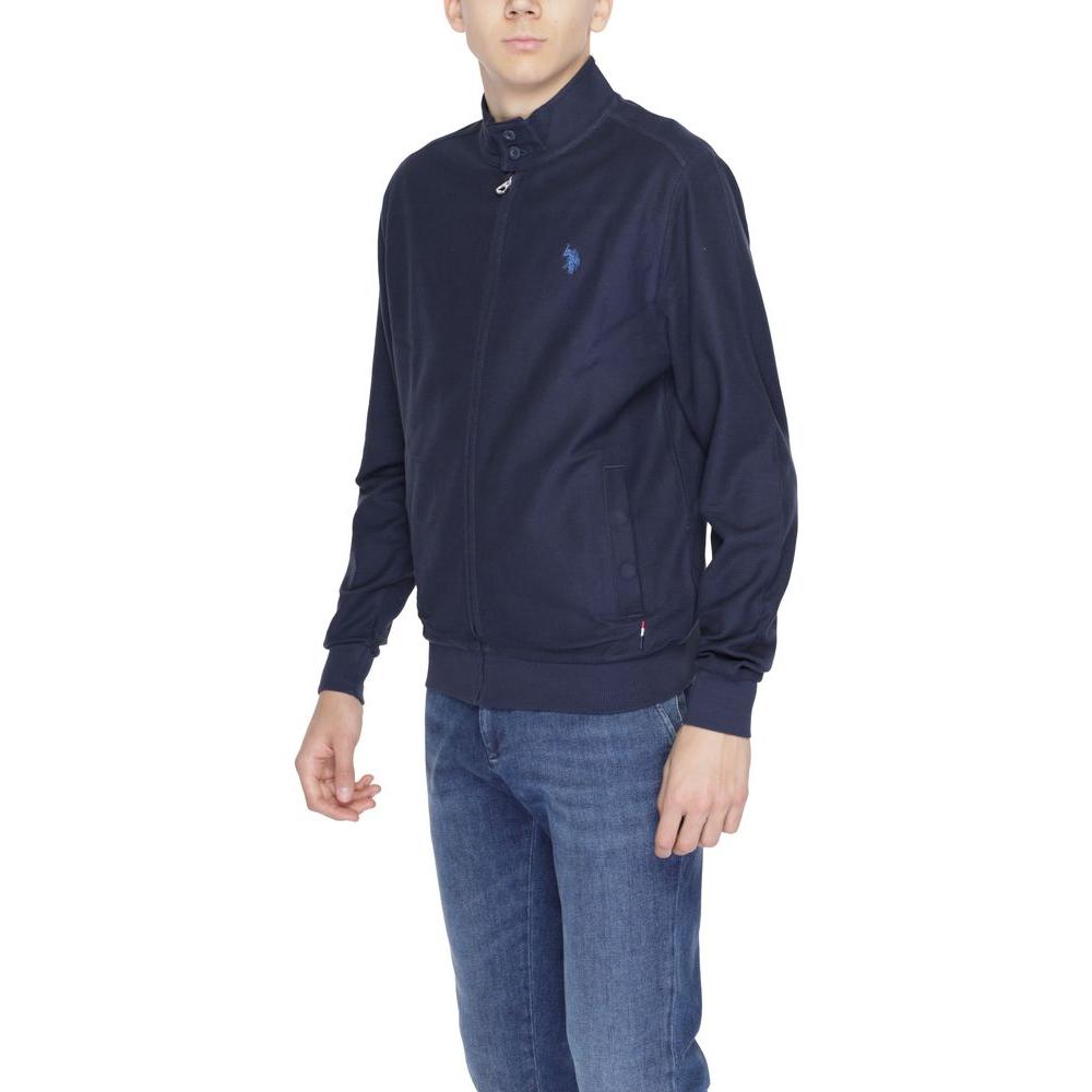 Man wearing a U.S. Polo Assn. blue cotton jacket with high collar and front zip closure, ideal for stylish spring and autumn wear.
