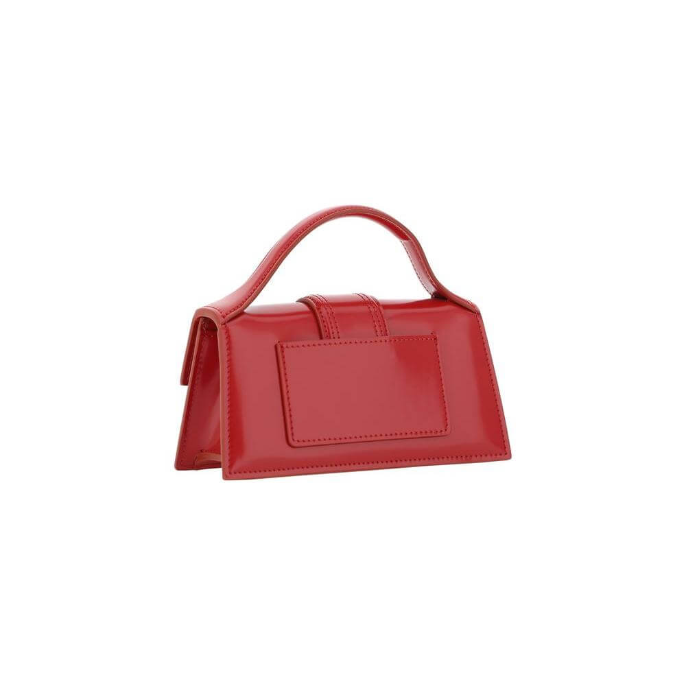 Red Jacquemus Le Grand Bambino handbag with flat top handle and adjustable strap, featuring a geometric design and iconic monogram plaque.