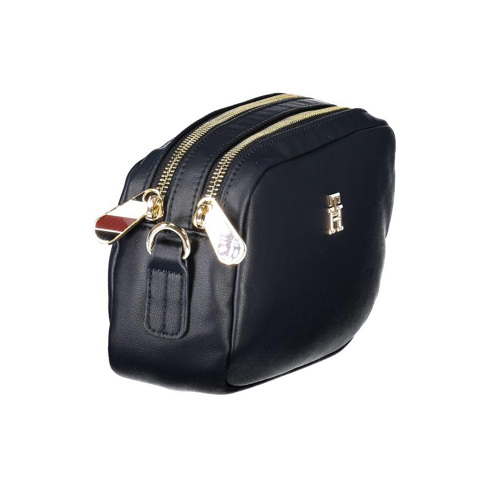 Black Tommy Hilfiger handbag with dual zippers and logo, featuring a sleek design and detachable strap for versatile styling.
